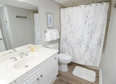 a bathroom with a sink and a toilet and a shower at Emerald Beach 1130 in Panama City Beach