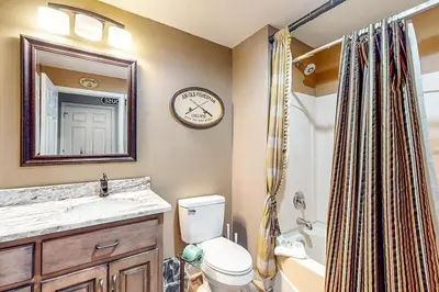 a bathroom with a toilet and a sink and a clock at Sterling Reef 902 in Panama City Beach