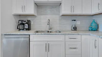 a kitchen with white cabinets and a sink at Villas At Sunset Beach B201 in Panama City Beach