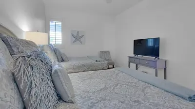 a living room with a bed and a tv at Villas At Sunset Beach B201 in Panama City Beach