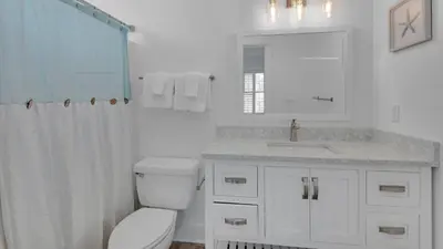 a white bathroom with a toilet and a sink at Villas At Sunset Beach B201 in Panama City Beach