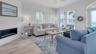 a living room with a blue couch and a tv at Villas At Sunset Beach B201 in Panama City Beach