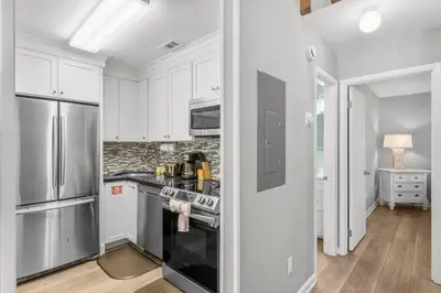 a kitchen with white cabinets and a stove top oven at Grey Zen in Panama City Beach