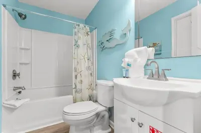 a bathroom with a white toilet and a sink at Grey Zen in Panama City Beach
