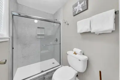 a bathroom with a toilet and a glass shower at Beachside Villas 1022 in Santa Rosa Beach