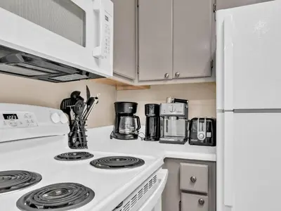 a kitchen with a white stove top oven next to a refrigerator at Beachside Villas 1211 in Santa Rosa Beach