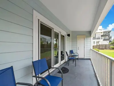 a porch with blue chairs on a house at Beachside Villas 1211 in Santa Rosa Beach
