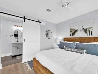 a white bedroom with a bed and a mirror at Beachside Villas 1131 in Santa Rosa Beach