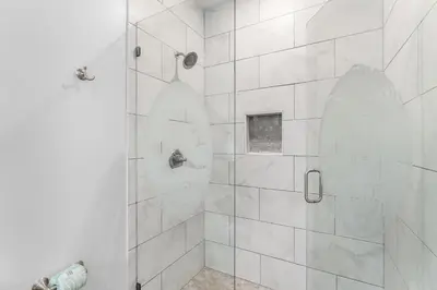 a bathroom with a shower with a glass door at Beach House - Lazee Daze by Panhandle Getaways in Panama City Beach