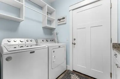a white kitchen with a stove and a washer at Beach House - Lazee Daze by Panhandle Getaways in Panama City Beach