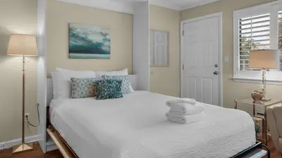 a bedroom with a white bed with towels on it at Hidden Beach 201 in Santa Rosa Beach