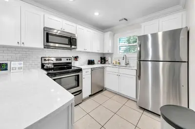 a kitchen with white cabinets and a stainless steel refrigerator at Beachside Villas 412 in Santa Rosa Beach