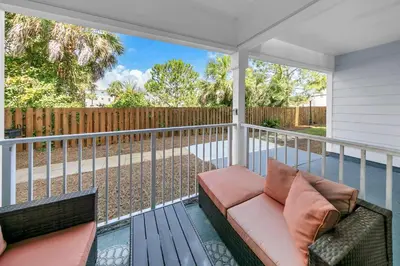 a porch with a couch and a fence at Beachside Villas 412 in Santa Rosa Beach