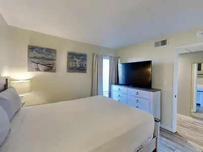 a bedroom with a bed and a flat screen tv at Edgewater Tower III #709 in Panama City Beach