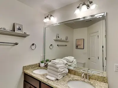 a bathroom with two sinks and a large mirror at The Pink Flamingo in Rosemary Beach
