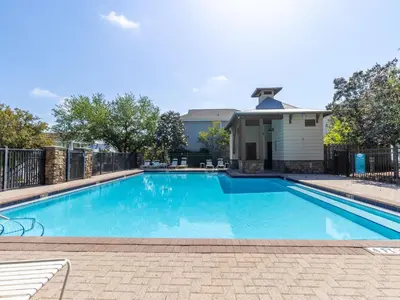 a large blue swimming pool with a fence at The Pink Flamingo in Rosemary Beach