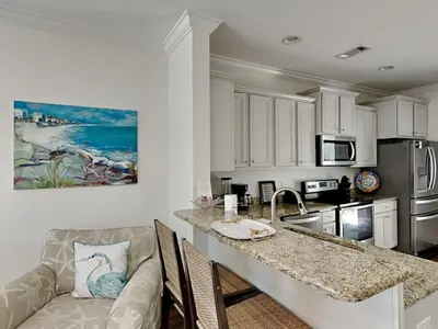 a kitchen with a kitchen island with a counter top at The Pink Flamingo in Rosemary Beach