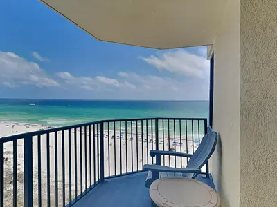 a balcony with a chair and a view of the beach at Sunbird Beach Resort #902 West in Panama City Beach