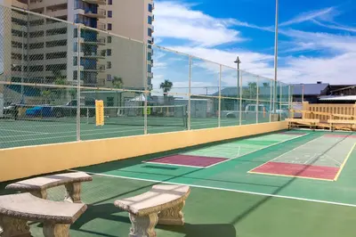 a tennis court with two benches on a tennis court at Sunbird Beach Resort #902 West in Panama City Beach