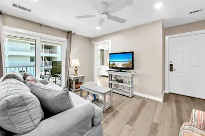 a living room with a couch and a flat screen tv at Beachside Villas 523 in Santa Rosa Beach