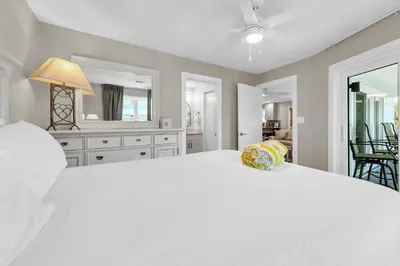 a bedroom with a large white bed and a mirror at Beachside Villas 523 in Santa Rosa Beach