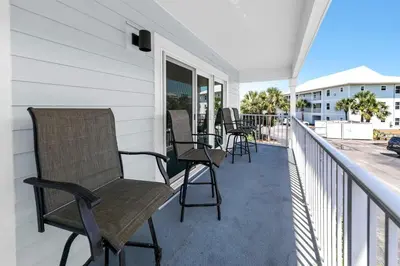 a porch with chairs and tables on a balcony at Beachside Villas 523 in Santa Rosa Beach