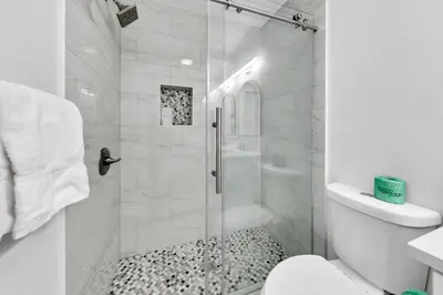 a white bathroom with a shower with a glass door at Beachside Villas 523 in Santa Rosa Beach