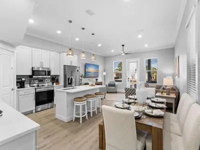 a kitchen and living room with a table and chairs at Deja Blue in Panama City Beach