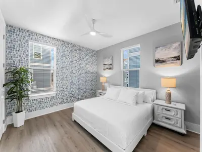 a bedroom with a white bed and blue tiled walls at Deja Blue in Panama City Beach