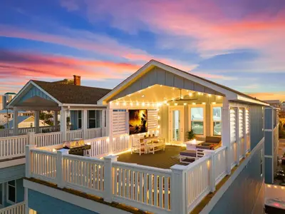 a house with a deck with lights on it at Deja Blue in Panama City Beach