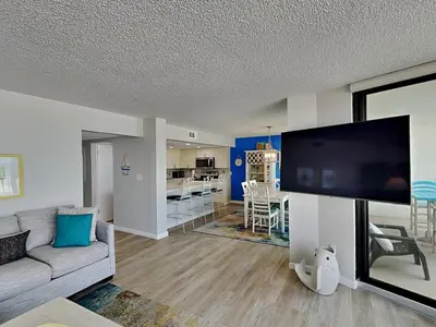 a living room with a couch and a flat screen tv at Edgewater Tower III #113 in Panama City Beach