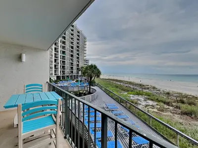 a balcony with blue chairs and a view of the beach at Edgewater Tower III #113 in Panama City Beach