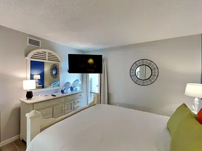 a bedroom with a white bed and a mirror at Edgewater Tower III #113 in Panama City Beach