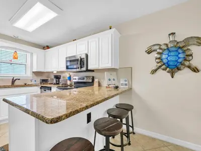 a kitchen with a counter with stools in it at Beachside Villas 613 in Santa Rosa Beach