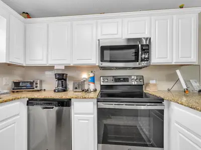 a kitchen with a stove and a microwave at Beachside Villas 613 in Santa Rosa Beach