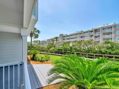 a balcony of a apartment building with palm trees at Beachside Villas 613 in Santa Rosa Beach
