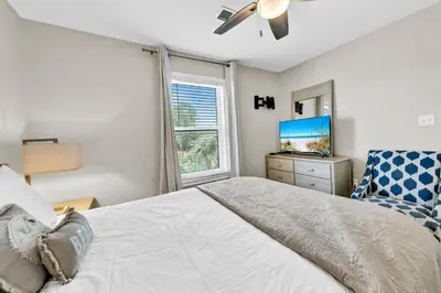 a bedroom with a bed and a tv and a window at Beachside Villas 823 in Santa Rosa Beach