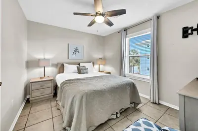 a bedroom with a bed with a ceiling fan and a window at Beachside Villas 823 in Santa Rosa Beach