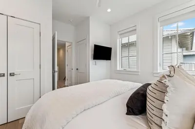 a white bedroom with a large bed and windows at 69 E Trigger Trail by 30A Escapes in Rosemary Beach