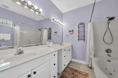 a white bathroom with a sink and a tub and a shower at Grouper Therapy in Santa Rosa Beach
