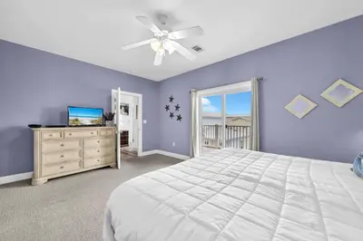 a bedroom with a white bed and a ceiling fan at Grouper Therapy in Santa Rosa Beach