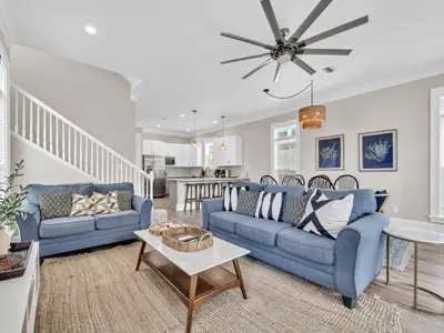 a living room with two blue couches and a table at Calliope in Rosemary Beach