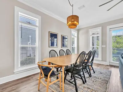 a dining room with a wooden table and chairs at Calliope in Rosemary Beach