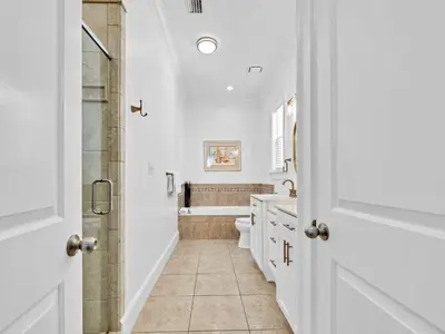 a white bathroom with a toilet and a shower at Calliope in Rosemary Beach