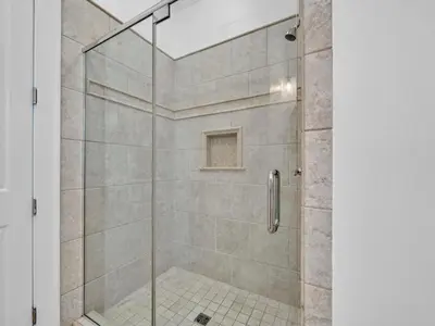 a shower with a glass door in a bathroom at Calliope in Rosemary Beach