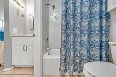 a bathroom with a blue shower curtain and a toilet at The Summit Unit 1215 in Panama City Beach