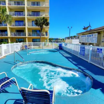 a swimming pool with two chairs and a building at The Summit Unit 1215 in Panama City Beach