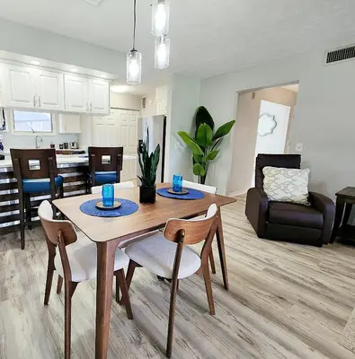 a kitchen and living room with a table and chairs at Blue By The Bay in Panama City Beach