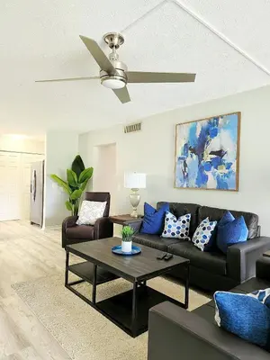 a living room with a couch and a ceiling fan at Blue By The Bay in Panama City Beach