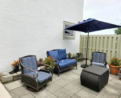 a patio with two chairs and an umbrella at Blue By The Bay in Panama City Beach